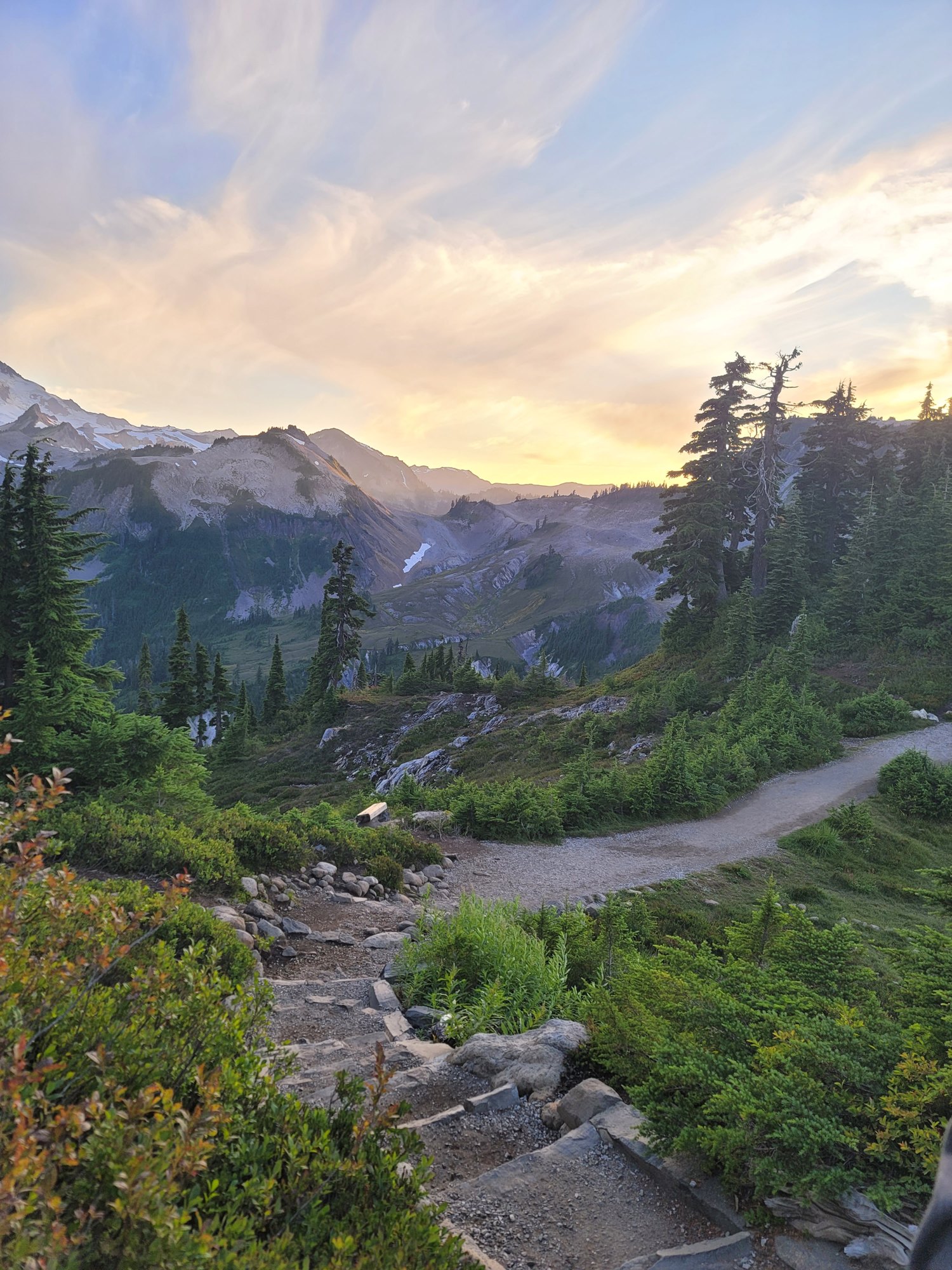 Golden-hour light over an alpine trail leading toward the peaks at Artist Point
