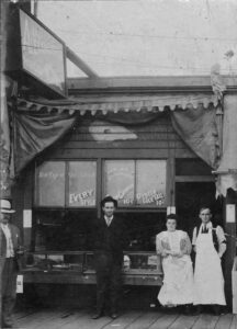 Around 1901 photo of four people in front of Alexander's Oyster House storefront in Bellingham