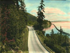 1926 hand-tinted photograph of a wooden trestle along Chuckanut Drive above Bellingham Bay