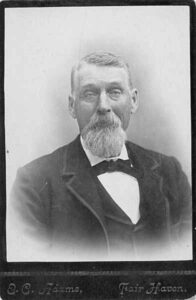 Studio cabinet-card portrait of a bearded man in a suit, Fairhaven, around 1885