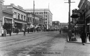 View down Holly Street in Bellingham around 1918 with streetcar tracks and storefronts