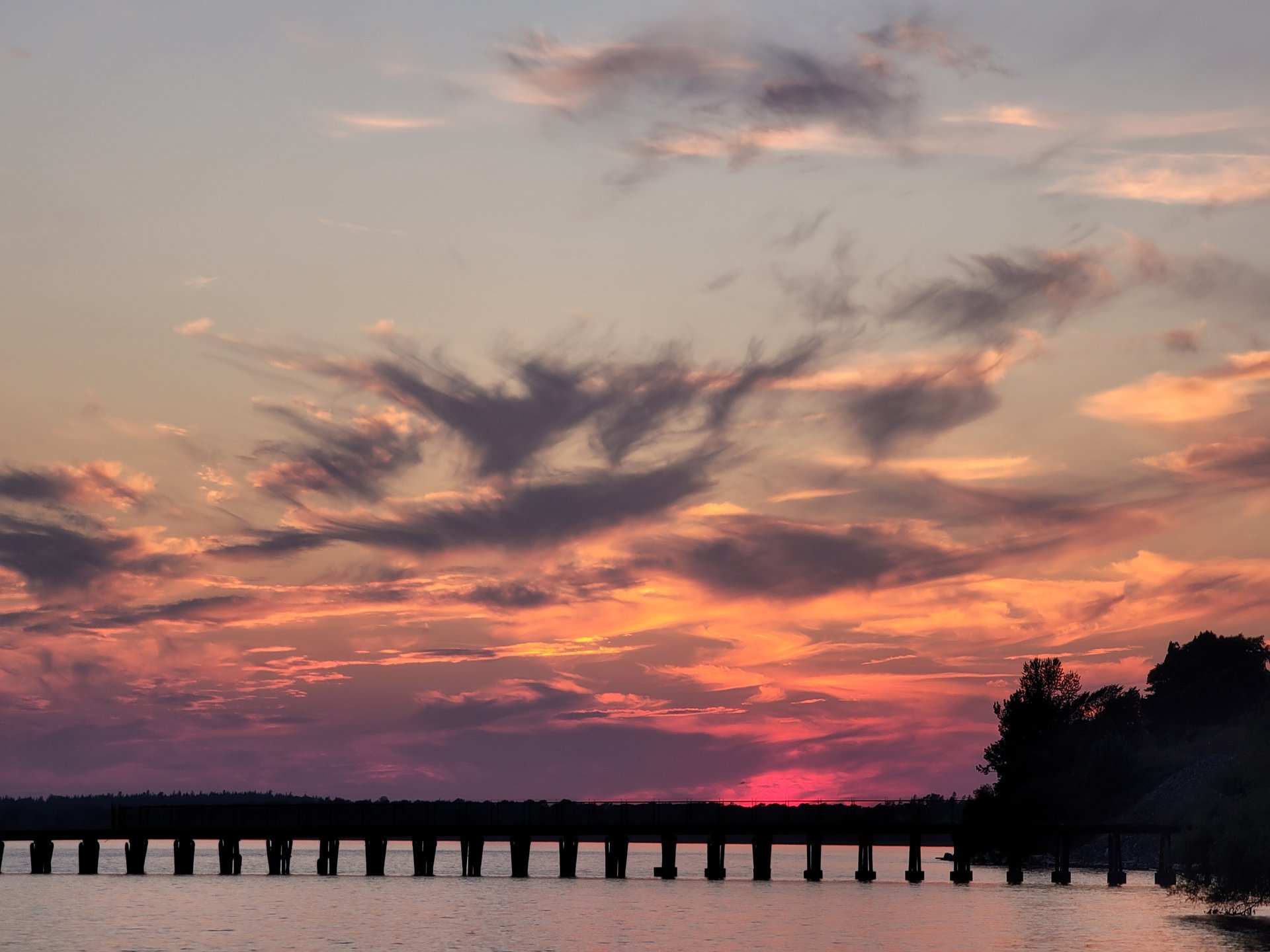 Sunset over the water with a silhouetted pier near Bellingham